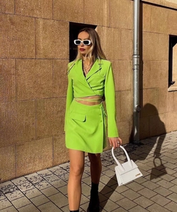 Outdoor shot of neon green cropped jacket and mini skirt set with detailed fabric texture