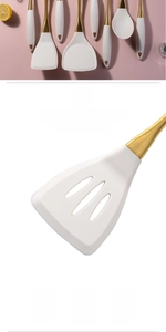 Detail of white silicone spatula with golden handle showing food-grade heat resistance