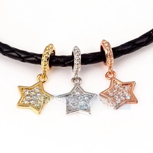 Detailed close-up of gold, silver and rose gold star charms with micro-paved cubic zirconia