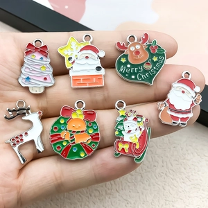 Hand holding assorted Christmas alloy charms including Santa, Reindeer and Xmas tree