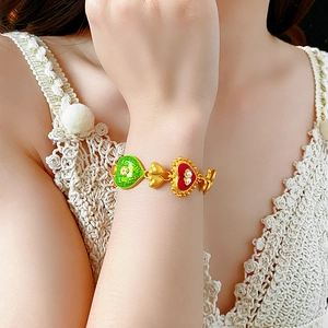 Close-up of vintage gold bracelet with colorful enamel hearts and small pearls