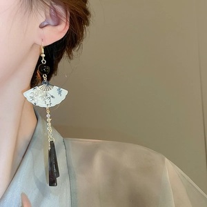 Détail de boucles d'oreilles éventail chinois avec motif bambou et longs glands sur mannequin