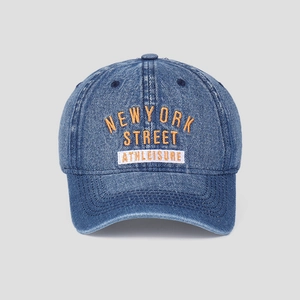Detail of washed denim baseball cap with orange embroidery and athleisure patch