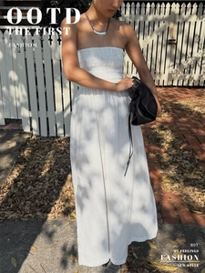 Detail view of the smocked bodice and elastic texture of a white strapless tube dress