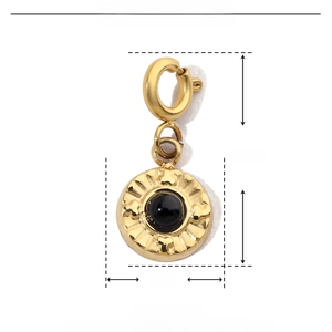 Macro view of a 16mm gold stainless steel pendant with black natural stone inlay