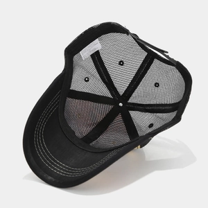 Detail of black mesh trucker hat showing internal stitching and white care label