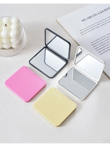 Detailed view of four colorful mini folding makeup mirrors in square plastic frames