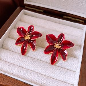 Dettaglio di orecchini vintage rosso scuro con bordi dorati in scatola porta gioie