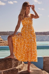 Outdoor shot of a tiered summer maxi dress with orange and white geometric prints