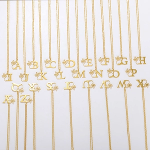 Collection of all 26 gold stainless steel alphabet necklaces with leaf-decorated pendants