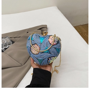 Detail of heart-shaped evening bag with floral sequins and golden crystal clasp