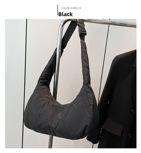 Détail du sac hobo matelassé en nylon noir avec bandoulière réglable et fini brillant