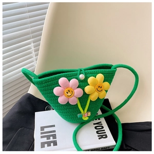 Nahaufnahme der grünen Strohtasche mit 3D-Smiley-Blumen und buntem Schultergurt