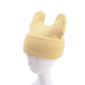 Detail of light yellow knit beanie with cute cat ears design on a white head model