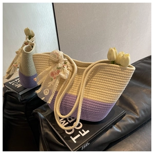 Detail of woven tote bag with purple accents and a floral silk scarf bow on a sofa