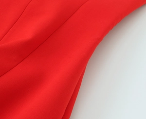 Close-up of red elastic fabric texture with clean stitching on a short bow dress