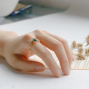 Detail of moss agate drop ring with vine leaves and zircons on 925 silver band