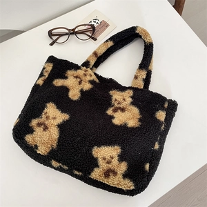 Detail of soft black faux shearling tote bag with brown teddy bear pattern and handles