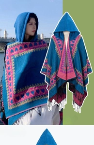 Détail du poncho à capuche ethnique avec motifs géométriques et finitions à franges