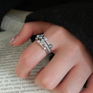 Close-up of triple-layer pearl ring with zircon accents on a model's hand