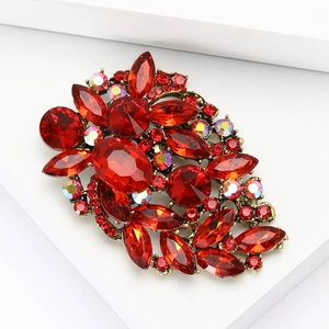 Vintage style red crystal flower brooch with rhinestone accents on white display