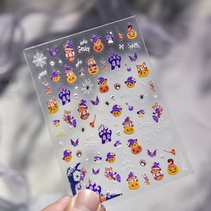 Vue macro d'autocollants pour ongles Halloween avec panda, citrouille et château magique