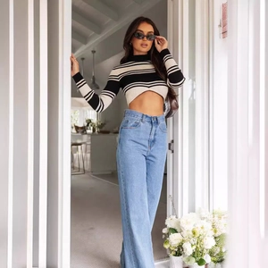 Women's high waist wide leg jeans paired with a striped crop top in a modern street style