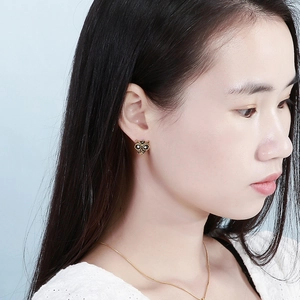 Gros plan d'une boucle d'oreille chouette vintage avec strass noirs et blancs