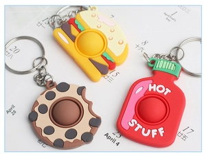 Detailed shot of food-shaped keychains including burger, cookie and hot sauce bottle