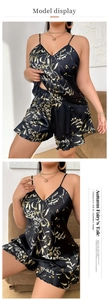 Detail view of black satin pajama set with floral print and ruffled hem shorts