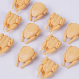 Miniature roasted chicken food keychain model made of resin on white background