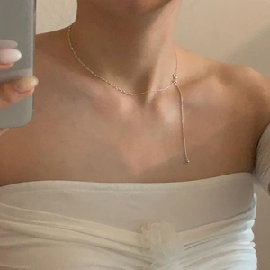 Detailed close-up of a delicate S925 sterling silver beaded chain necklace worn by a model