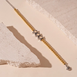 Vue détaillée d'un bracelet en acier inoxydable avec perles dorées et éléments étoiles