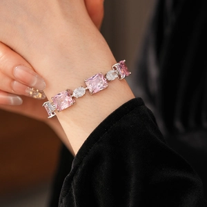 Close-up of silver bracelet with square pink crystals and clear zircon on a wrist