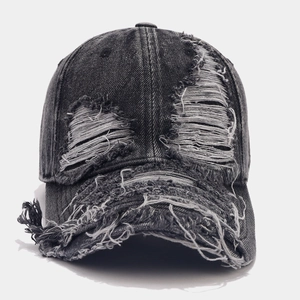 Vintage washed black distressed baseball cap with ripped holes and frayed denim edges