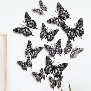 Detailed close-up of various sized black hollow-out 3D butterfly wall stickers on wall