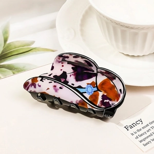 Close-up of cowboy hat shaped hair claw clip with purple and orange marble pattern