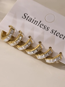 Detail of gold stainless steel hoop earrings with inlaid square cut clear zircons