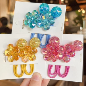 Close-up of colorful camellia resin charms on elastic hair ties with laser finish