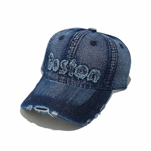 Dettaglio cappello denim con ricamo BOSTON in rilievo ed effetti strappati vintage