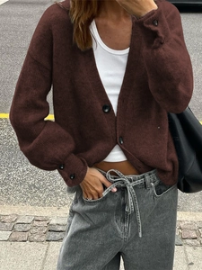 Gros plan d'un cardigan en maille marron foncé de haute qualité avec col en V et boutons