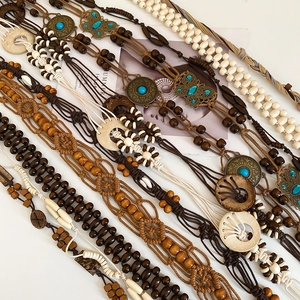 Close-up of handmade bohemian waist belts with wooden beads and vintage butterfly buckle