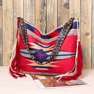 Detail of bohemian tote featuring geometric ethnic patterns and red fringe accents