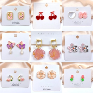 Collection of nine S925 silver needle floral and heart earrings on a satin display