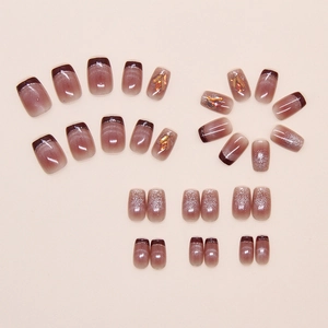 Detailed view of cat-eye press-on nails with 3D amber crystals and French glitter accents