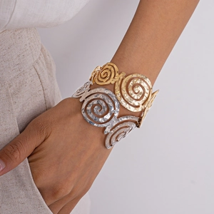 Détail de la texture martelée sur un bracelet jonc ouvert doré au design spirale