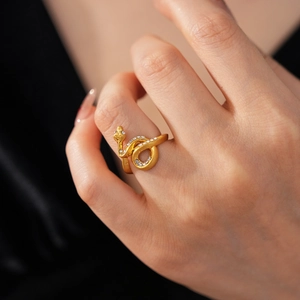 Macro detail of gold-plated snake ring with sparkling white rhinestones and matte texture