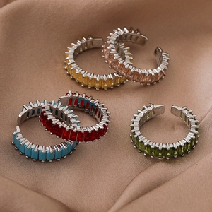 Minimalist silver open rings set with colorful rectangular zircons on beige silk