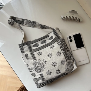 Detailed macro view of retro paisley print cotton linen shoulder bag with brand woven label