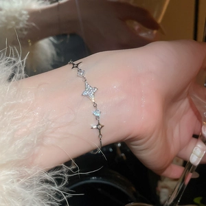 Detail eines funkelnden Zirkon-Stern-Anhängers am Handgelenk mit verstellbarer Kette
